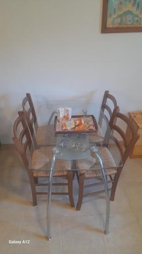 a table with four chairs and a table with food on it at Rahati in Pramanta - Ραχάτι στου Τσακτσίρα in Pramanta