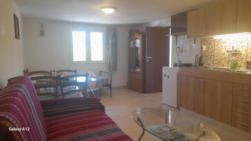 a kitchen and a living room with a couch and a table at Rahati in Pramanta - Ραχάτι στου Τσακτσίρα in Pramanta