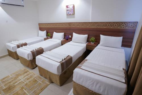 a room with three beds in a room at فندق سيف بلص 1 من اورفانا in Makkah