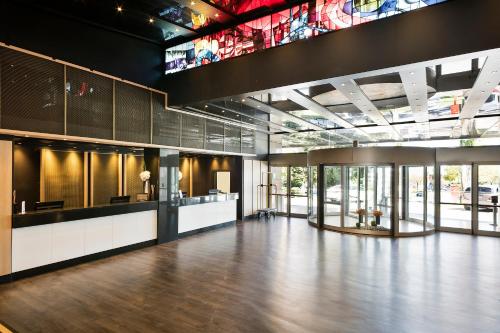 a large lobby with a wooden floor and a stained glass window at Melia Barajas in Madrid
