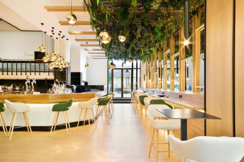 a restaurant with green chairs and a bar at Melia Barajas in Madrid