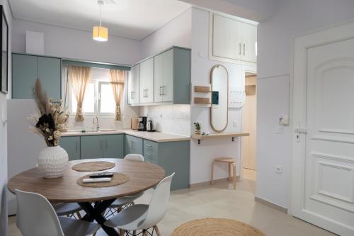 a kitchen with a wooden table and white cabinets at Olia's House in Skala Eresou