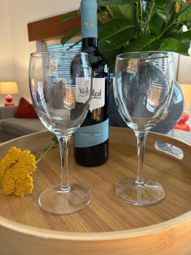 two wine glasses on a table with a bottle of wine at Casa Na Vila in Vila Pouca de Aguiar