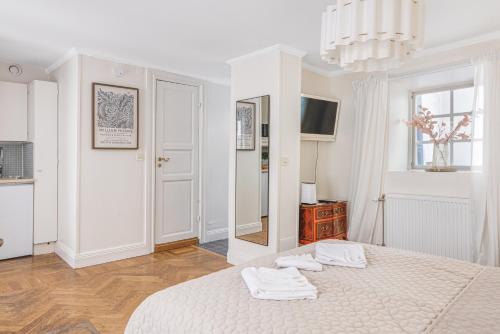 a white bedroom with a bed and a mirror at Apartment in Old Town in Stockholm