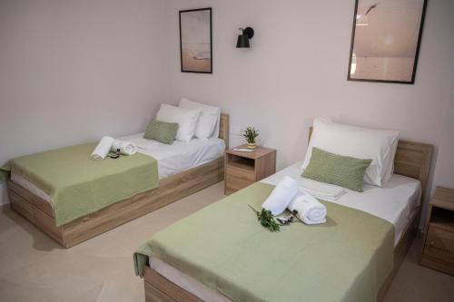 a bedroom with two beds and a mirror at Olia's House in Skala Eresou