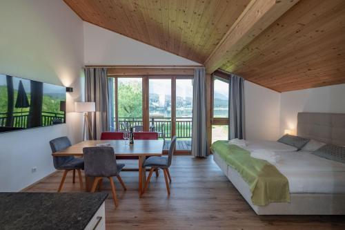 sypialnia z łóżkiem, biurkiem i stołem w obiekcie Lake Resort Pressegger See w mieście Hermagor