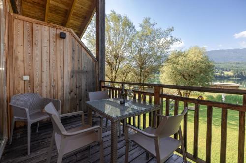 a table and chairs on the deck of a cabin at Lake Resort Pressegger See in Hermagor