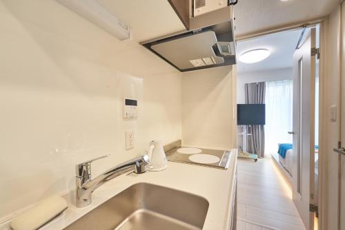 a white bathroom with a sink and a mirror at Yamanote walk for 8mins, New APT on Local shopping street in Tokyo
