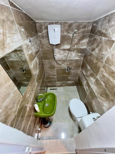 a bathroom with a toilet and a green stool at Kıbrıs Evi (Cyprus House) in Famagusta