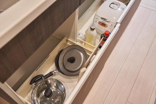 a kitchen with a frying pan and a sink in a cabinet at Yamanote walk for 8mins, New APT on Local shopping street in Tokyo
