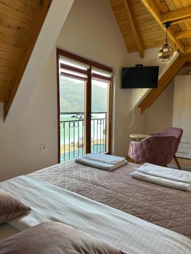 a bedroom with two beds and a large window at Stara pruga Jaz 2 in Višegrad