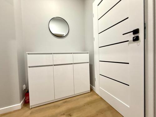 a white closet with a door and a mirror at Nowoczesny Dom z Ogrodem w Warszawie 'NOWY OBIEKT' in Warsaw