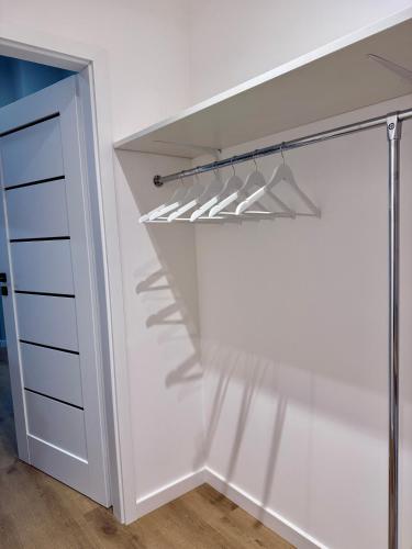 a walk in closet with white walls and white drawers at Nowoczesny Dom z Ogrodem w Warszawie 'NOWY OBIEKT' in Warsaw