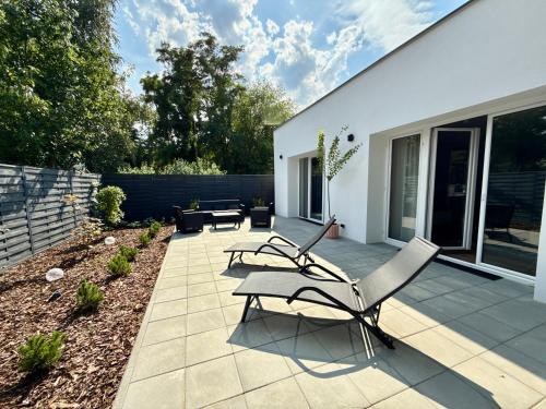 a patio with two chairs and a table at Nowoczesny Dom z Ogrodem w Warszawie 'NOWY OBIEKT' in Warsaw