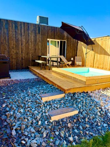 a backyard with a pool and a table and an umbrella at Wooden SPA in Hradec Králové