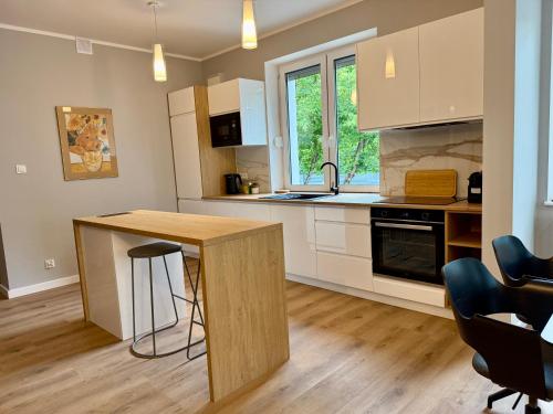 a kitchen with white cabinets and a wooden counter top at Nowoczesny Dom z Ogrodem w Warszawie 'NOWY OBIEKT' in Warsaw