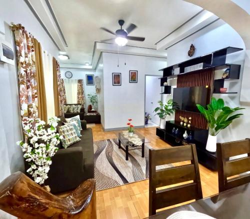 a living room with a couch and a tv at Cozy Home in Dadiangas, General Santos City - Perfect for Families Travelers in Dulongabong