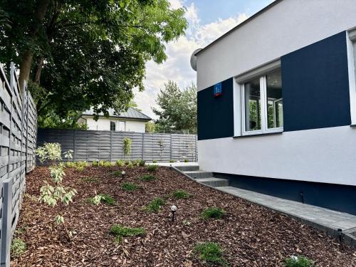 a blue and white house with a yard at Nowoczesny Dom z Ogrodem w Warszawie 'NOWY OBIEKT' in Warsaw