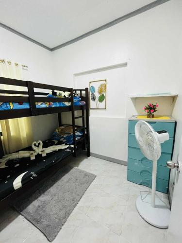 a room with two bunk beds and a fan at Cozy Home in Dadiangas, General Santos City - Perfect for Families Travelers in Dulongabong
