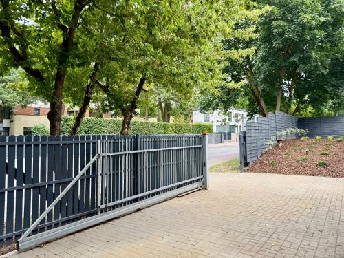 a blue fence next to a sidewalk with trees at Nowoczesny Dom z Ogrodem w Warszawie 'NOWY OBIEKT' in Warsaw