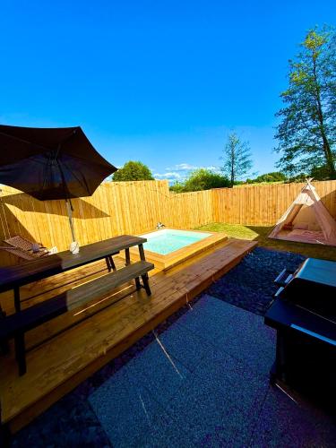 a wooden deck with a bench and an umbrella at Wooden SPA in Hradec Králové