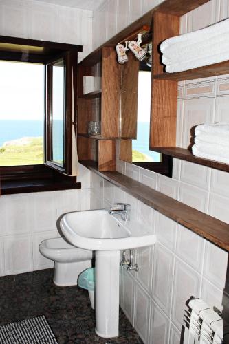 a bathroom with a sink and a toilet and a window at Casa de Aldea El Valle in Buelna