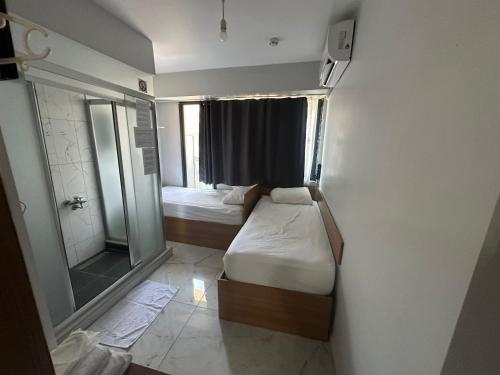 a small room with two beds and a shower at Nr1 Pansiyon in Canakkale