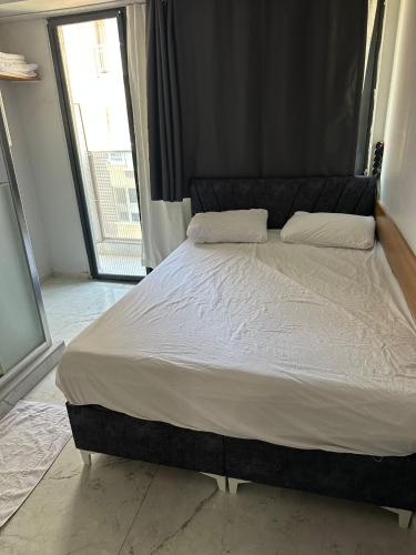 a large bed in a bedroom with a large window at Nr1 Pansiyon in Canakkale