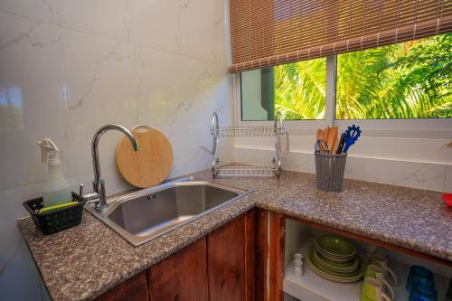 a kitchen counter with a sink and a window at Milles Montagnes Residence in Anse a La Mouche