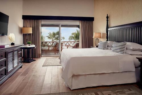 a bedroom with a large white bed and a balcony at Hacienda del Mar Los Cabos, an Autograph Collection All-Inclusive Resort in Cabo San Lucas