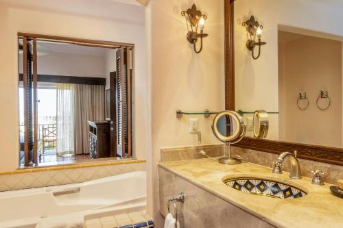 a bathroom with a sink and a tub and a mirror at Hacienda del Mar Los Cabos, an Autograph Collection All-Inclusive Resort in Cabo San Lucas