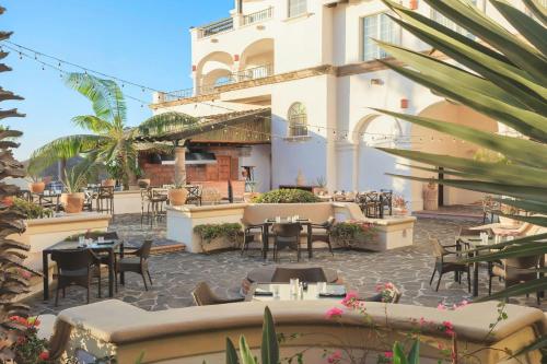 a patio of a hotel with tables and chairs at Hacienda del Mar Los Cabos, an Autograph Collection All-Inclusive Resort in Cabo San Lucas