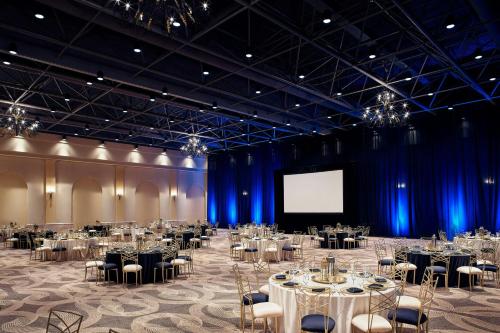 a large room with tables and chairs and a screen at Hacienda del Mar Los Cabos, an Autograph Collection All-Inclusive Resort in Cabo San Lucas