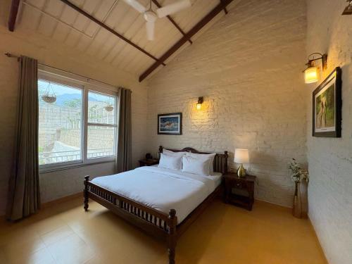 Un dormitorio con una cama y una ventana grande. en The Cliff House, 3BR LUX Villa 2km to Rajpur Road, en Dehradun