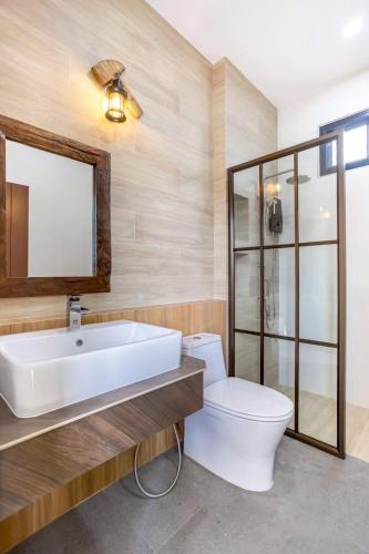 a bathroom with a sink and a toilet and a mirror at Fedora Moon Pool Villa Khanom in Khanom