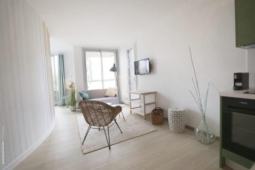 un salon avec une chaise et un canapé dans l'établissement 50m from the beach ultra cosy balcony near the cen, à La Rochelle