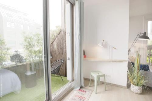 une chambre avec un lit et une porte coulissante en verre dans l'établissement 50m from the beach ultra cosy balcony near the cen, à La Rochelle