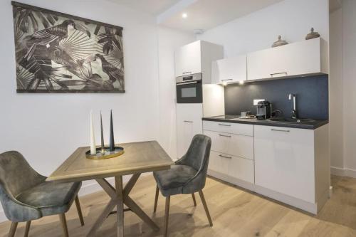 een keuken met een tafel en stoelen in een kamer bij Bel appartement à 2 pas du vieux port in La Rochelle