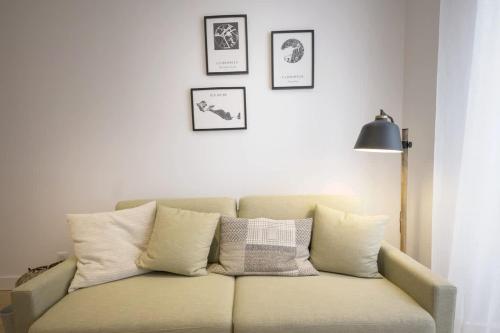 un canapé avec des coussins dessus dans un salon dans l'établissement Bel appartement à 2 pas du vieux port, à La Rochelle