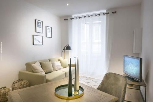 een woonkamer met een bank en een tafel bij Bel appartement à 2 pas du vieux port in La Rochelle