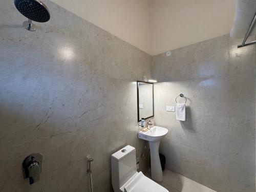 Un baño con un inodoro blanco y un lavabo. en The Cliff House, 3BR LUX Villa 2km to Rajpur Road, en Dehradun
