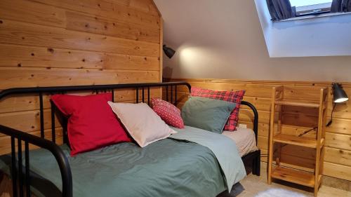 a bedroom with a bed with pillows on it at Domki Na Wzgórzu in Nowica