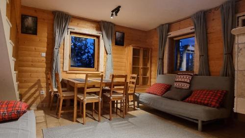 a living room with a table and a couch at Domki Na Wzgórzu in Nowica