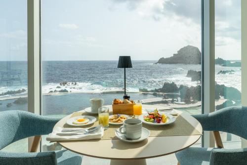 a table with food and a view of the ocean at Aqua Natura Madeira in Porto Moniz