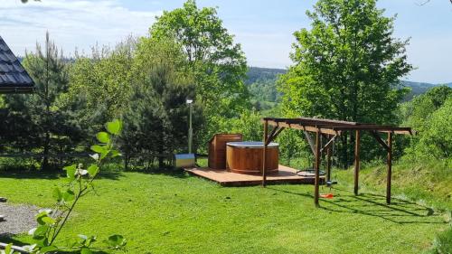 a gazebo with a barrel in the grass at Domki Na Wzgórzu in Nowica