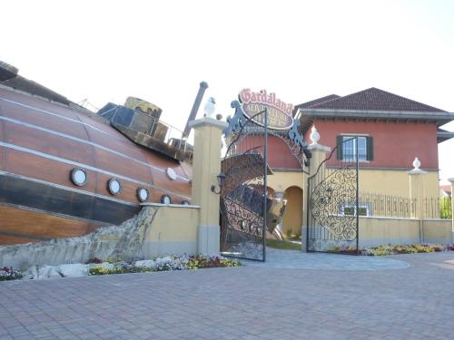 a house with a large boat next to a gate at Gardaland Adventure Hotel in Castelnuovo del Garda