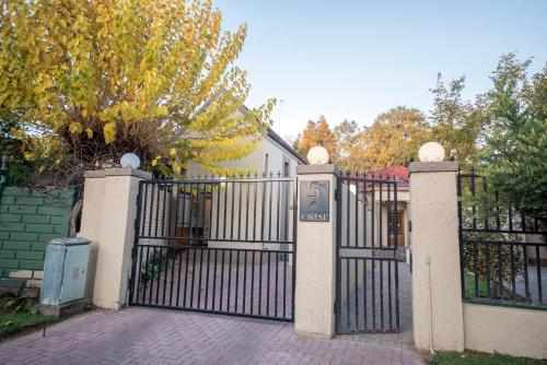 a gate to a house with a driveway at Crisp Guest Rooms in Bloemfontein
