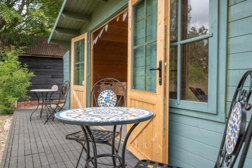 a patio with a table and chairs on a house at The Hayloft Boundary Farm, Framlingham in Woodbridge