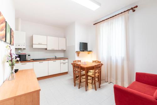 a kitchen and dining room with a table and a red chair at Albergo Diffuso Balcone sul Friuli in Clauzetto