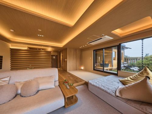 a living room with a couch and a large window at Hotel New Wakasa in Nara